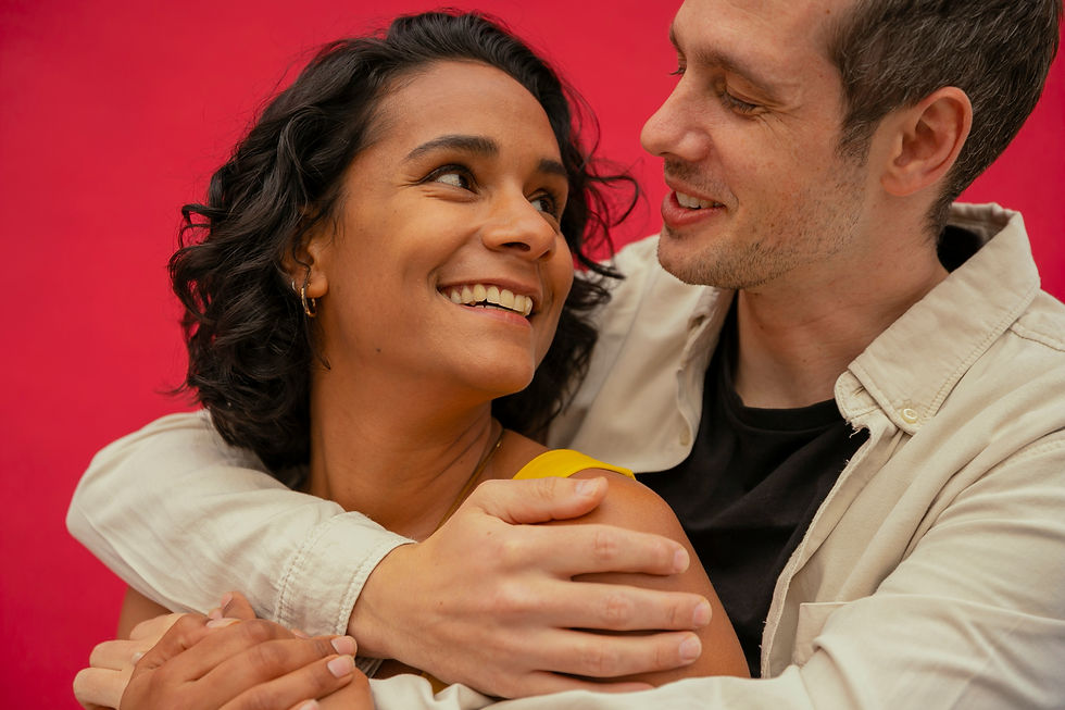 a couple smiling at each other with arms around each other