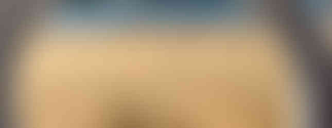 View of a beach sand artist working as seen through the ornate white railing of Lan Concha Beach in San Sebastian, Spain