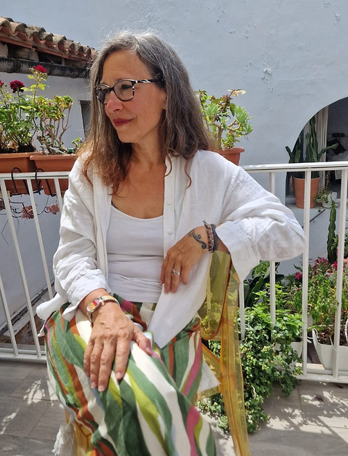 Bild von Chantal Gattone sitzend auf einem Stuhl auf einer Terrasse, umgeben von Pflanzen