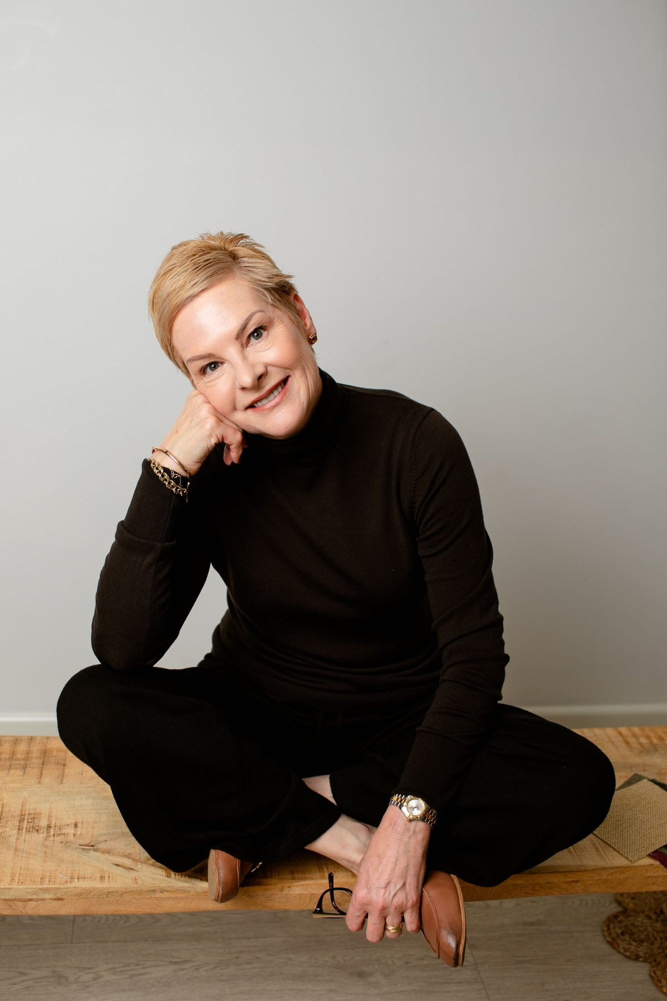 Ewa Doherty, Creative Director of Tablelands Interior Design, seated on a timber bench