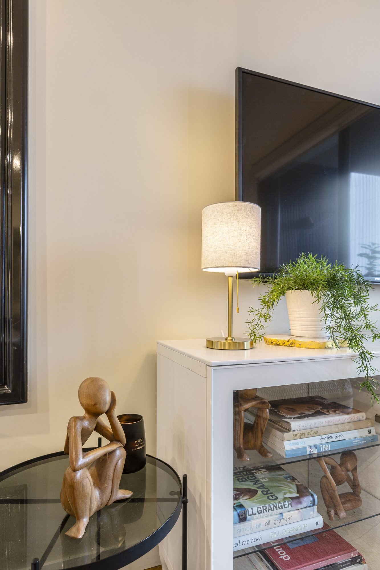Styled joinery with table lamp, books and timber sculpture