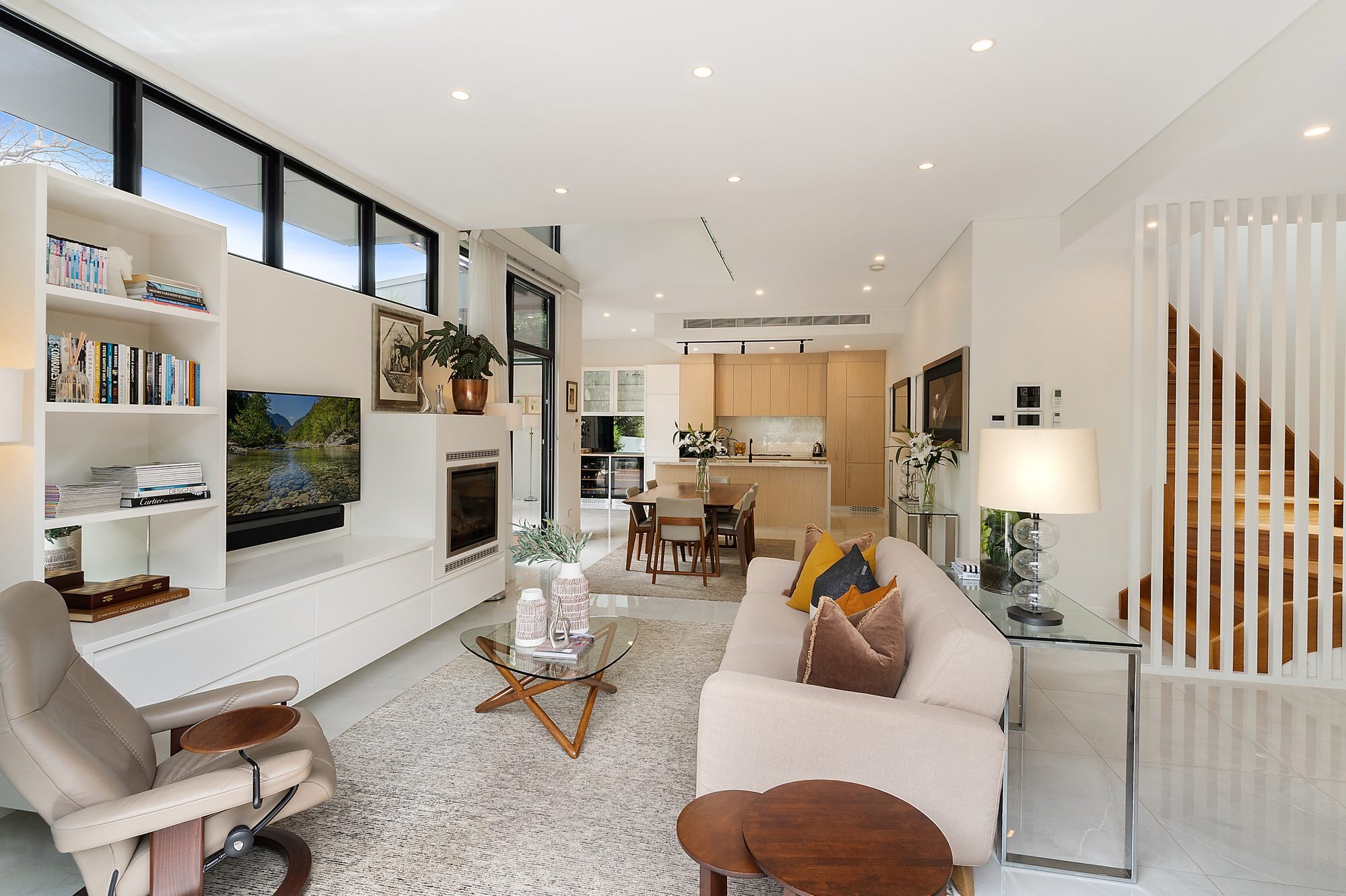 Open plan living and dining space with built-in joinery, timber and white finishes