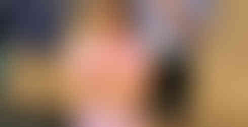 A young girl is standing in front a teen boy, who is holding a piece of paper that says "Monkey."