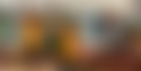 Two children (a boy and a girl) in yellow, an adult in green with an adventurer vest, and someone dresses as a bird with their hands up