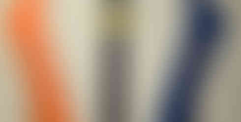 Paper canoes and paddles staples to the wall with a sign labeled "Canoe Rentals" on it in the middle. The canoe on the left is orange and the canoe on the right is blue. There is also a smaller sign below the Canoe Rental sign pointing right labeled "Launch."