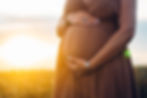 Pregnant Woman Caressing Belly On Wheat Natural Field Background. Belly baby bump in 2nd t