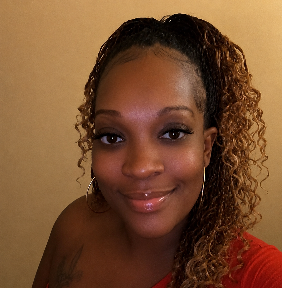 Smiling woman with long curly hair wearing a red top.