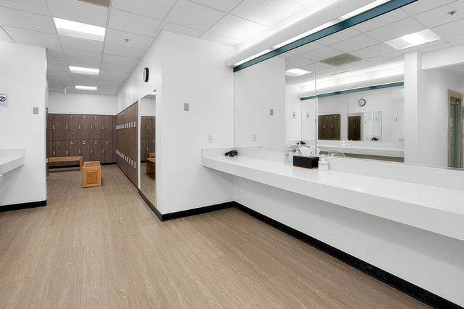 Clean and spacious locker room interior with mirrors and wooden lockers visible.