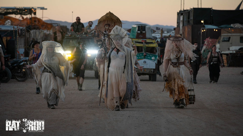 Women in white walk down Main St at Wasteland Weekend to initiate their new sister, Sigil
