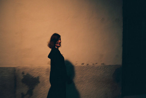 Die Schriftstellerin vor einer ins goldene Licht getauchten Mauer