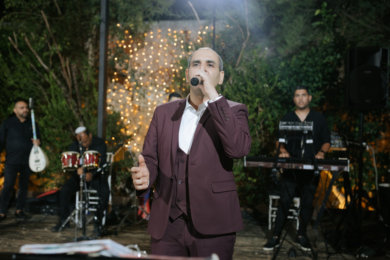 נתנאל כהן שר עם הרכב נגנים באירוע