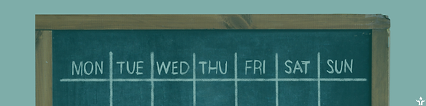 A chalkboard with the days of the week written on it, implying a column-based calendar.