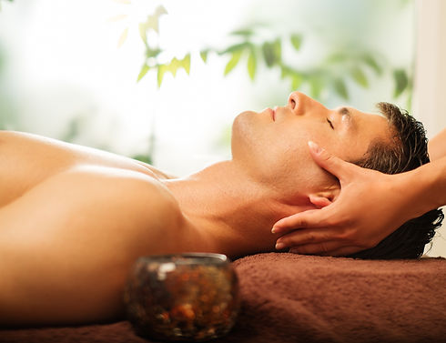 Man lying down having therapeutic head massage.