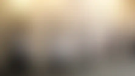 Children and adults walk in procession along a church wall with gold plaques and crosses. They carry papers, creating a solemn atmosphere.