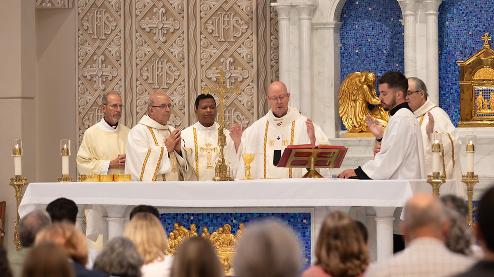 Clergy in white vestments celebrate Mass at a gold altar before a blue mosaic backdrop, with worshippers seated in front.