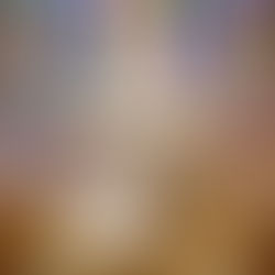 Bride and groom kneel at altar in a church with colorful stained glass backdrop. Priest stands with raised hands. Ceremony atmosphere.