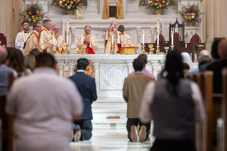 The congregation kneels in prayer facing the altar during the consecration.