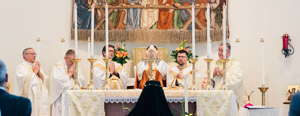 A newly professed religious sister kneels before the altar during Mass as clergy celebrate the Eucharist.