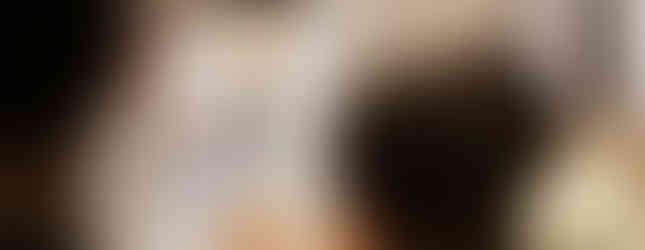 Deacon in blue and white robes at pulpit, reading in ornate church with crucifix and "Jubilee Cross" sign, solemn atmosphere.