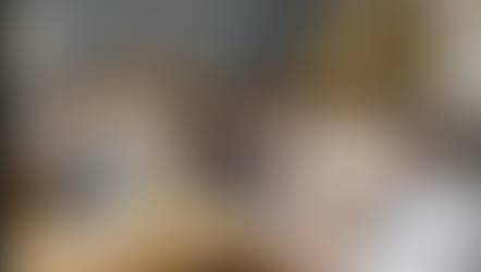 Women sitting on a couch, smiling and reading the book "Letter to Artists." A cozy living room setting with flowers and snacks on the table.