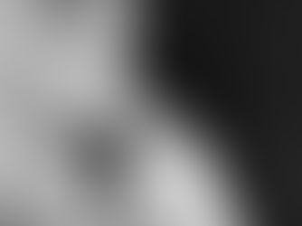 Black and white image of a baby sleeping in a knitted sweater, holding an adult's hand, evoking a tender and peaceful mood.