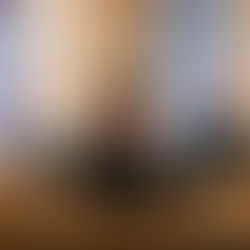 Men in suits sit on pews in a church with stained glass windows, hands clasped in prayer, creating a solemn atmosphere.