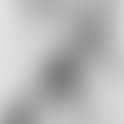 Man in period clothing leans on a walking stick in rocky terrain. He looks determined, set against a rugged mountain backdrop. Black and white photo.