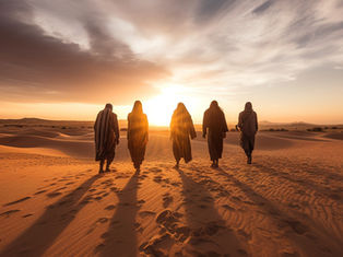 Five cloaked figures walk across desert dunes toward a glowing sunset, their long shadows stretching behind them.