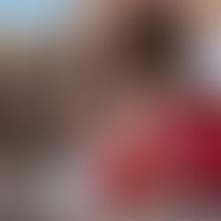 People in red outfits and colorful scarves kneel in front of a shrine with candles and flowers. A sign reads "AVOID THEFT PLEASE PLACE YOUR OFFERING."