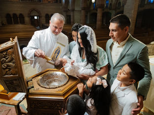 Bautizo en iglesia: sacerdote vierte agua sobre un bebé mientras la madre, el padre y niños observan con emoción.