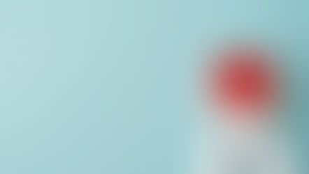 Hands in white sleeves hold a red heart against a pale blue background, conveying warmth and care.