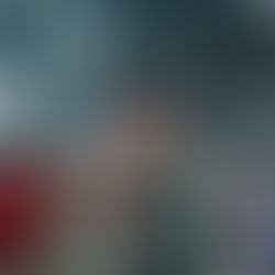 Smiling man and woman at a large indoor event with a crowd and bright lights in the stadium. They wear lanyards and casual clothes. Energetic mood.