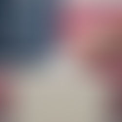 Hand placing a ballot into a box against the backdrop of a U.S. flag, symbolizing voting and patriotism.