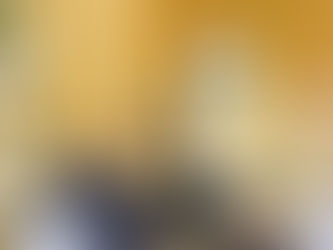 Priest in white robe speaks at a podium in a church. Congregation stands, facing altar. Cross and plants visible. Calm atmosphere.