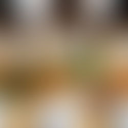 Three people with hands clasped in prayer around a table set with Thanksgiving foods like turkey, pie, and salad. Warm, inviting atmosphere.