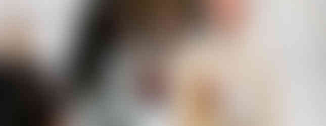 Priest in white robe giving communion to a woman in a church. Ornate altar in background. Calm, reverent atmosphere.