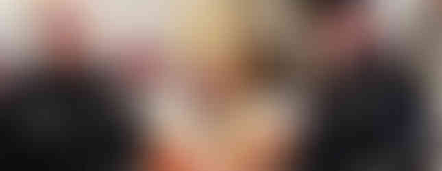 Police officers flanking a smiling bishop in ornate robes and mitre, holding a staff. Bright church interior with red and white decor.