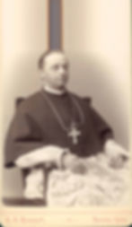 Sepia studio portrait of a seated Catholic clergyman in ornate robes and cross; text reads A. E. Rinehart, Denver, Colo.