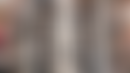 A procession of people in white robes walks down an aisle flanked by uniformed individuals. Crowd watches from sides, creating a solemn mood.