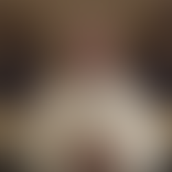 A man in religious attire speaks, standing in front of ornate book stands with open texts. Decorative gold and black backgrounds.