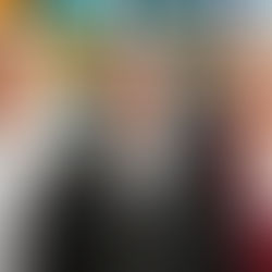 Three elderly people smiling, a priest, a nun, and a woman in a pink blazer. Colorful stained glass background enhances warmth.