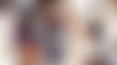 Three people outdoors, one adult bending, another crouched giving a high-five to child in a "Fiat Fest" shirt. Lively, sunny setting.