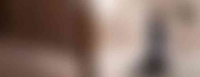 Altar server kneels in prayer near the sanctuary steps, holding folded vestments in a quiet moment of the liturgy.