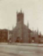 Sepia photo of a Gothic brick church in Denver with spires, people and bicycles outside, and copyright text at bottom.