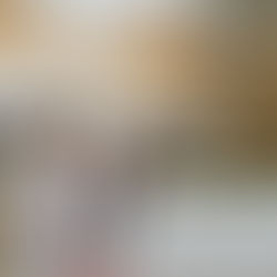 Clergy in white robes and purple stoles stand and pray by a flower-covered altar in a church. The wooden ceiling and a cross are visible.