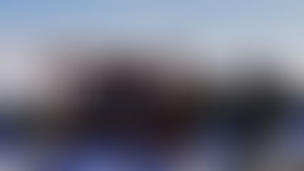 Wooden sign reading "Welcome to Colorful Colorado" amidst snowy trees under a clear blue sky.