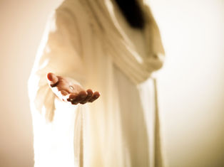 Outstretched hand in white robe, highlighting a small metallic object, warm glowing background, serene and inviting atmosphere.