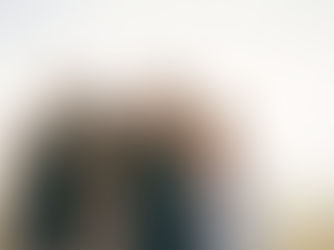 Four friends laugh together outdoors, wearing casual clothes and sunglasses, against a bright sky. Warm, joyful mood.