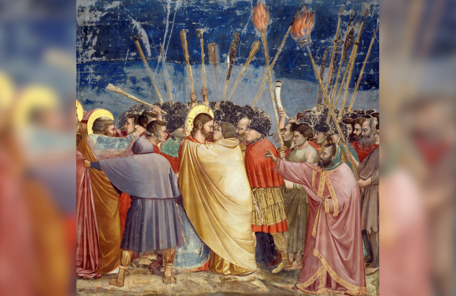 A dramatic scene with a group of people holding torches. A man in a golden robe is embraced. The night sky is in the background.