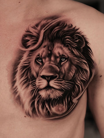 Realistische leeuw tattoo op borst met krachtige blik en fijne schaduwen